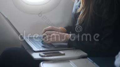 坐在<strong>飞机</strong>上使用笔记本电脑或个人电脑的女人